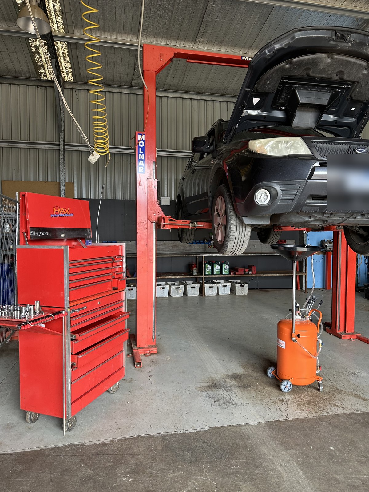 Subaru Forester up on the hoist for an oil change