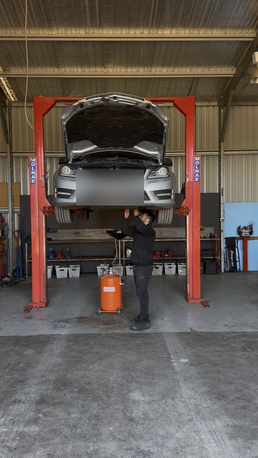 Checking the oil on a Mercedes-Benz up on the hoist